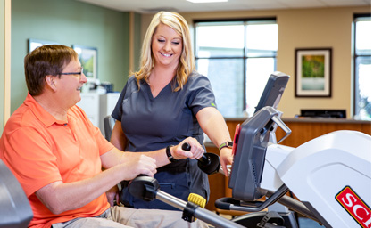 Rehabilitation specialist working with a patient using physical therapy equipment