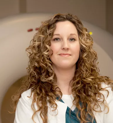 Imaging technician standing in front of an MRI machine