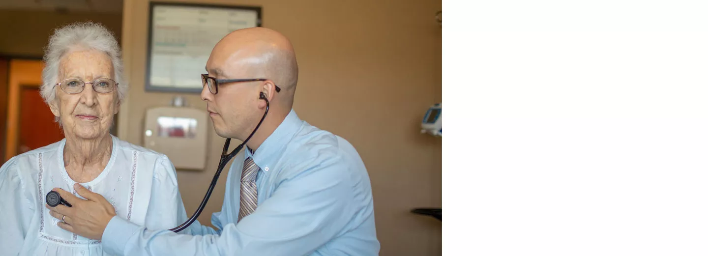 Doctor listening to an older patient's heart with a stethoscope