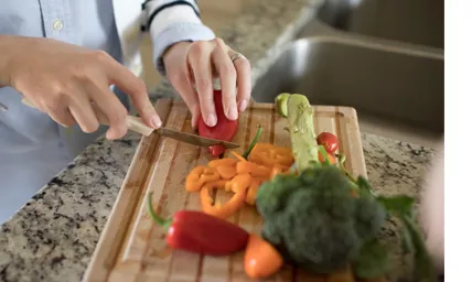 Woman cutting vegetables on a cutting board
