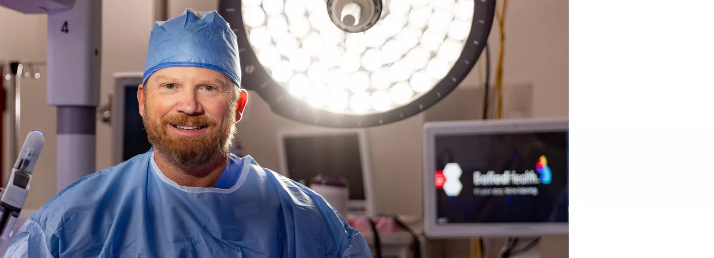 Surgeon wearing a surgical cap in operating room in front of a robotics surgery system