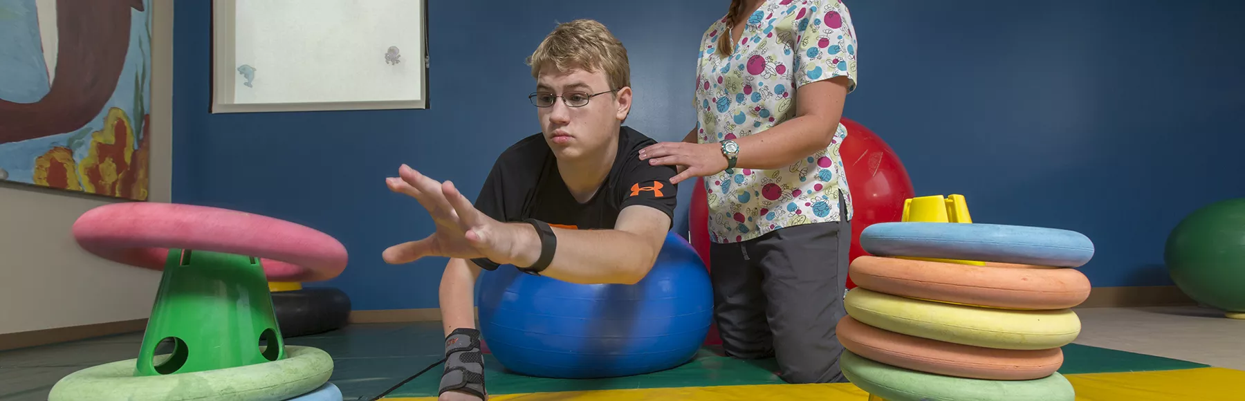 young man doing therapy exercises with therapist